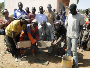 Pose de la 1ère pièrre de l'école de Kalagué par le président de 2AEFE, le chef de village et la représentante des femmes de Kalagué 