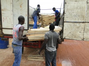 Chargement des planchers dans le camion pour confection de tables-bancs à Dogoro